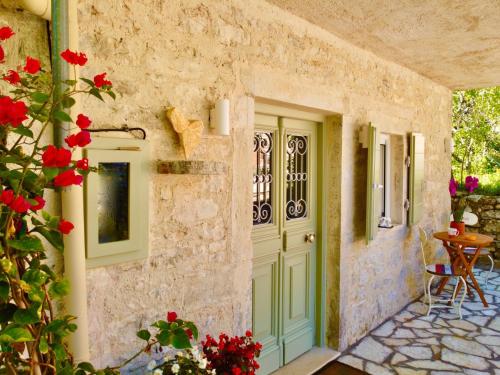 une porte d'entrée d'une maison avec des fleurs rouges dans l'établissement Villa Eva Agni with private pool, à Agní