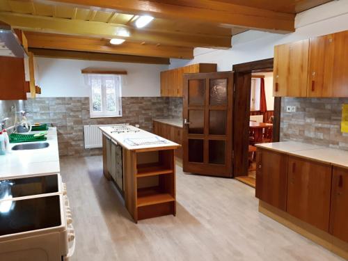a large kitchen with wooden cabinets and white counter tops at Horská chata U Pekařů in Pec pod Sněžkou
