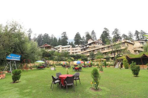 a group of tables and chairs in a park at Snow Valley Resorts & Spa Manali in Manāli