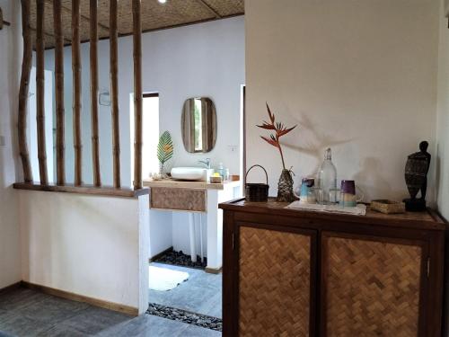 a bathroom with a sink and a staircase with a mirror at Valerie Lodge in San Vicente
