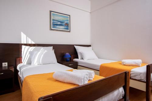 a hotel room with two beds with towels on them at Apartments Lazarić in Lopar