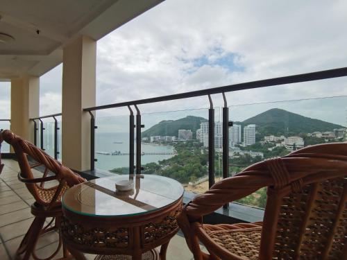 a balcony with a table and chairs and a view at Sanya Yikehai View Apartments in Sanya