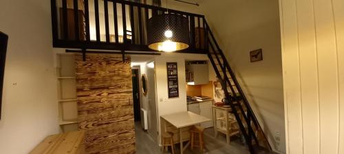 une chambre avec un escalier, une table et une cuisine dans l'établissement Duplex Arc en Ciel - Les Deux Alpes, à Mont-de-Lans