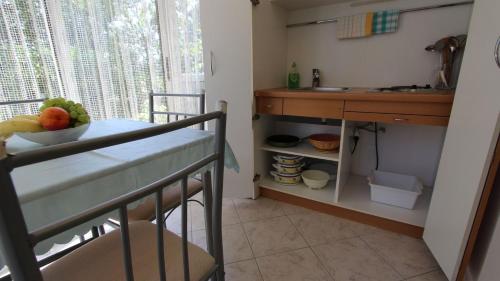 una cucina con lavandino e tavolo con cesto di frutta di Apartments Darko a Porat