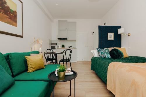 a living room with a green couch and a table at L Ajax Airport Bitwy Warszawskiej in Warsaw