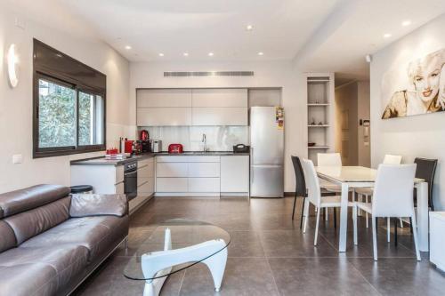 Il dispose d'une cuisine et d'un salon avec un canapé et une table. dans l'établissement Luxury 3BR Apt Centrally Located & 5-min to Beach by Sea N' Rent, à Tel Aviv