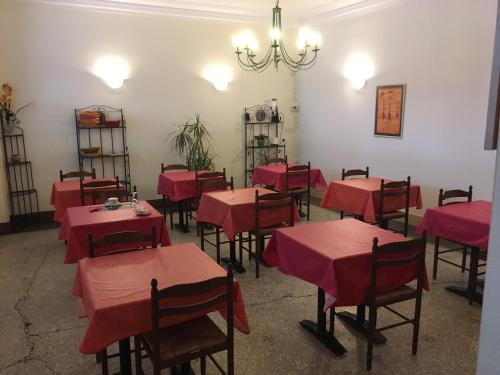 une salle à manger avec des tables et des chaises rouges et un lustre dans l'établissement Hotel le Rallye, à Soissons