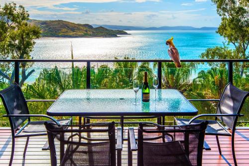 a table with a bird sitting on top of it on a balcony at Shorelines 2 on Hamilton Island by HamoRent in Hamilton Island