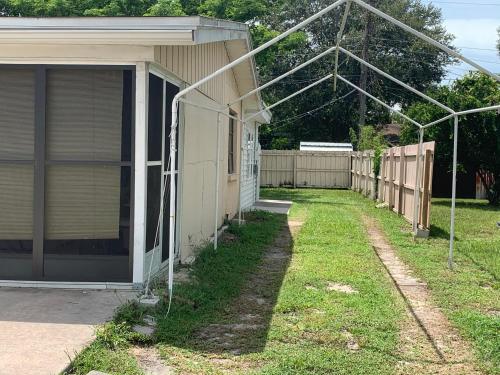a yard with a house with a garage and a fence at Cozy Studio only 10 minutes by car of Siesta Key in Sarasota
