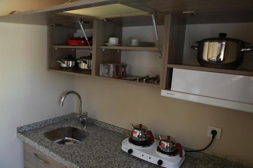 伊斯坦堡的住宿－比林奇公寓酒店，厨房柜台设有水槽和炉灶。