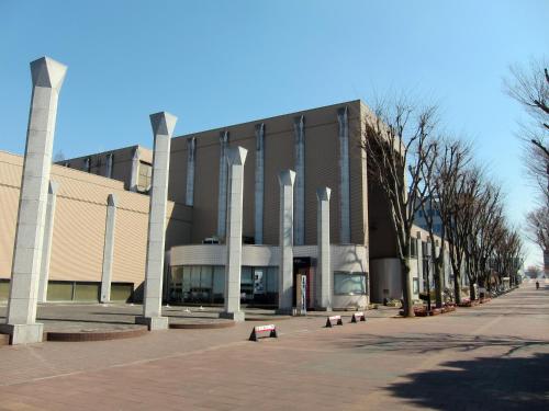 a large building with pillars in front of a street at Tabist Tsukuba Sky Hotel in Tsukuba