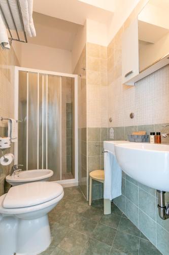 a bathroom with a toilet and a sink at Hotel Baya - in centro, sul mare in Milano Marittima