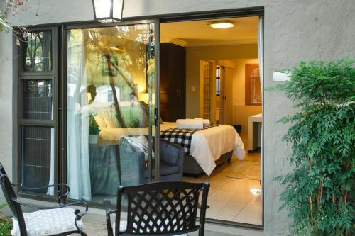 a glass door leading to a bedroom with a bed at Argyll B&B in Oudtshoorn