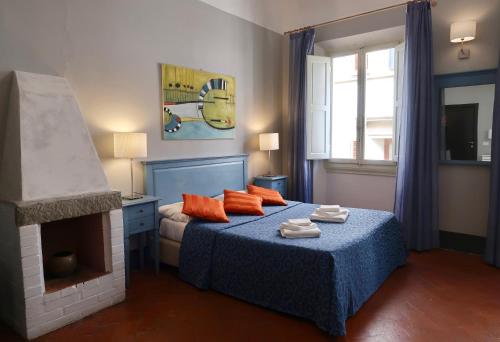 a bedroom with a bed with orange pillows and a fireplace at Locanda Della Musica in Florence