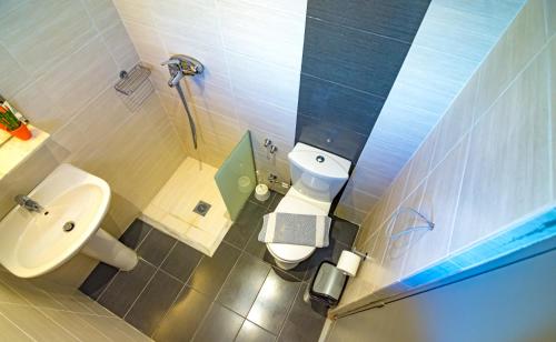 a small bathroom with a sink and a toilet at N E P center Hotel Rodos in Rhodes Town