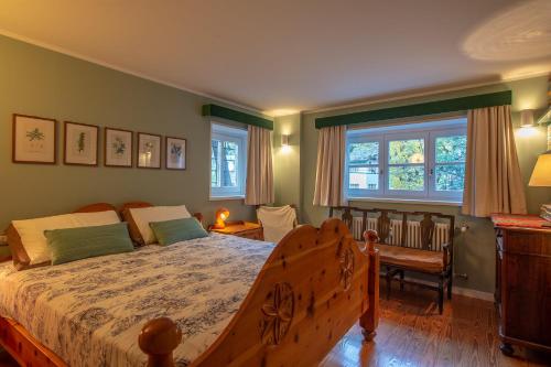 una camera con letto, scrivania e finestre di L'Atelier du Temps - PincherleStyle Apartment a Courmayeur