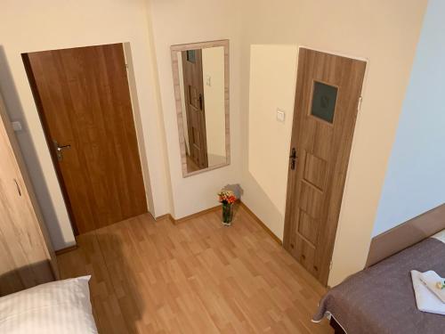 a room with two doors and a vase of flowers at OW Meduza i Biala Mewa in Międzyzdroje