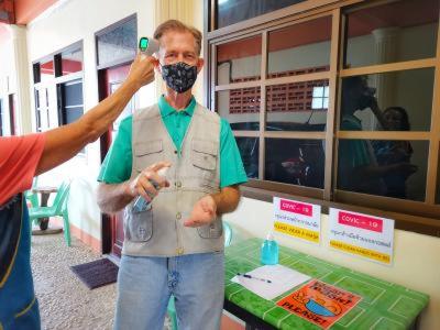 a man wearing a mask while talking on a cell phone at Ban Sulada Guest House in Laem Ngop