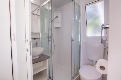 a bathroom with a shower and a toilet and a sink at Mobile Homes Delta Marine at Campsite Rapoća in Nerezine