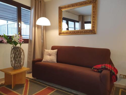 un soggiorno con divano marrone e specchio di Cretes Blanches Matterhorn a Breuil-Cervinia