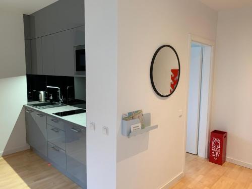 a kitchen with gray cabinets and a mirror on the wall at Sopocka Bryza in Sopot