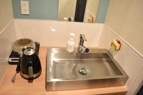 a kitchen sink with a tea kettle next to it at Shinsaibashi House in Osaka