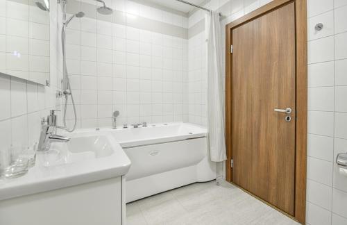 a bathroom with a sink and a tub and a toilet at Alpha Business-Hotel in Kirov