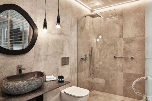 a bathroom with a sink and a toilet and a shower at Volcano Luxury Suites Milos - Adults Only in Paliochori
