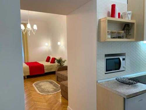 a room with a bed and a living room with a television at Siesta apartment on Stefanyka in Lviv