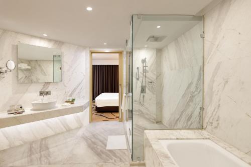 y baño con ducha y lavamanos. en Pride Plaza Hotel, Aerocity New Delhi, en Nueva Delhi