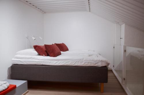 Un dormitorio con una cama con almohadas rojas. en Luttokolo, Saariselkä en Saariselka