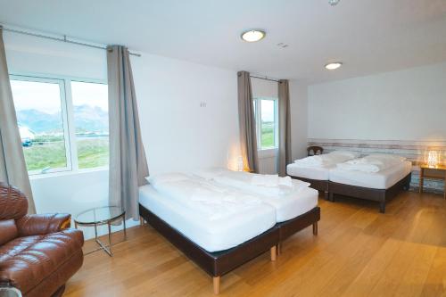 a hotel room with two beds and a couch at Álfheimar Hotel in Borgarfjörður Eystri