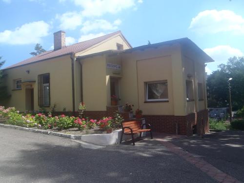 a yellow house with a bench in front of it at OW Meduza i Biala Mewa in Międzyzdroje