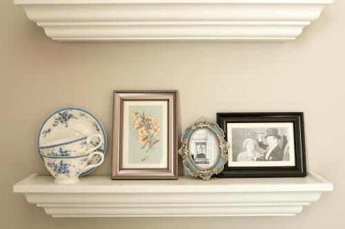 a shelf with three pictures and a vase on it at The Bailey's Hotel London Kensington in London