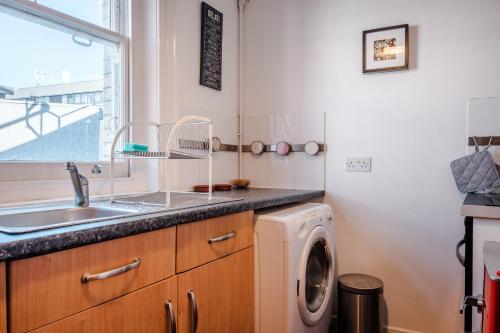 uma cozinha com pia e máquina de lavar em Oxford Street London by Threstle em Londres