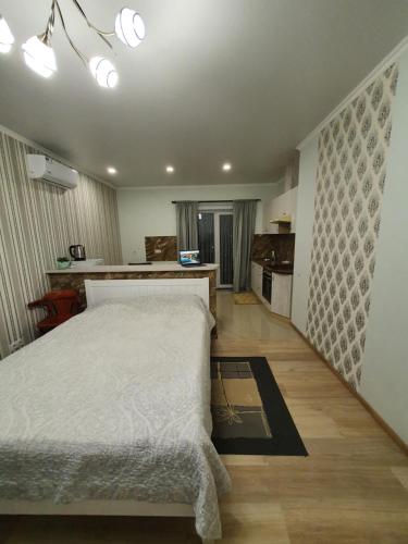 Cet appartement comprend une chambre avec un lit blanc et une cuisine. dans l'établissement Квартира-студія, à Loutsk