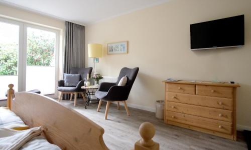 a bedroom with a bed and a tv on the wall at Hus op de Diek in Sankt Peter-Ording