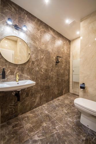 a bathroom with a sink and a toilet and a mirror at Apartments on Antonovycha in Kyiv