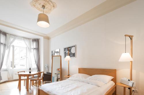 a white bedroom with a bed and a table at The BEST place in Prague - Old Town in Prague