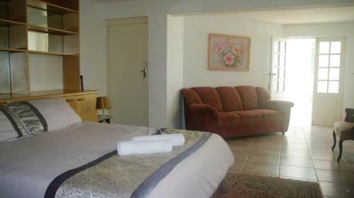 a bedroom with a large bed and a couch at Thoko-Zani Beach House in KwaDukuza