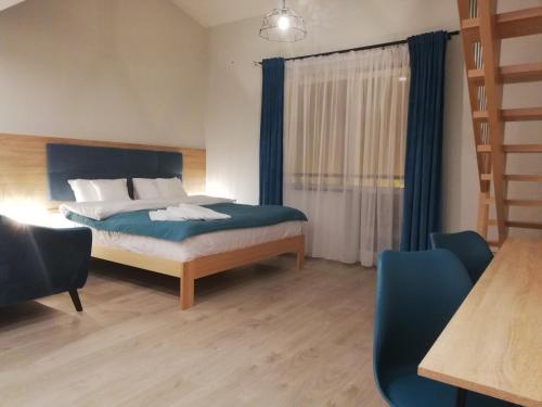 um quarto com uma cama e uma janela com cortinas azuis em U ŹRÓDEŁ em Wisla