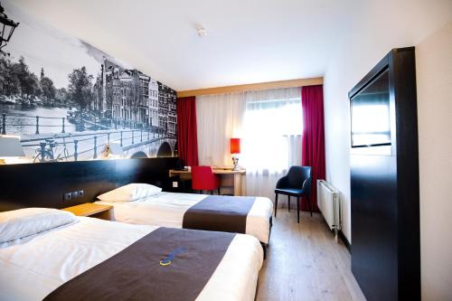 a hotel room with two beds and a desk at Bastion Hotel Schiphol Hoofddorp in Hoofddorp