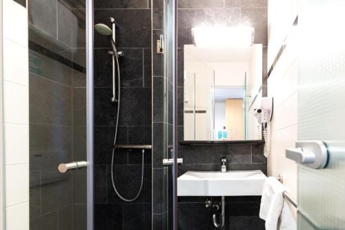 een badkamer met een douche en een wastafel bij Bastion Hotel Schiphol Hoofddorp in Hoofddorp