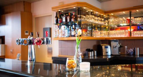 a bar with a vase with a flower on a counter at Bastion Hotel Schiphol Hoofddorp in Hoofddorp