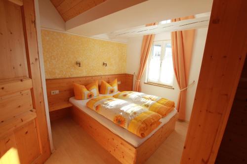 Schlafzimmer mit einem Bett mit orangefarbener und gelber Bettwäsche in der Unterkunft Gästehaus Pfefferle Hotel garni und Ferienwohnungen in Sigmaringen