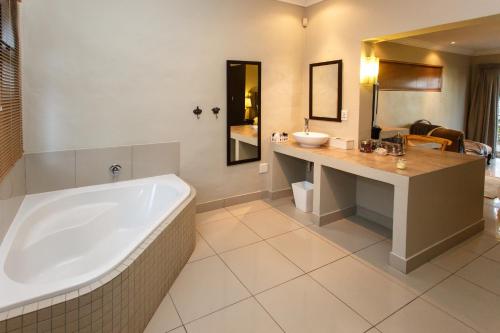 a large bathroom with a tub and a sink at Argyll B&B in Oudtshoorn