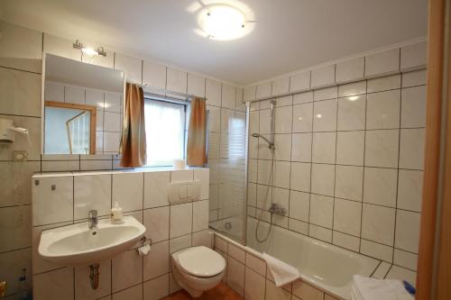 ein Badezimmer mit einem Waschbecken, einem WC und einer Badewanne in der Unterkunft Gästehaus Pfefferle Hotel garni und Ferienwohnungen in Sigmaringen