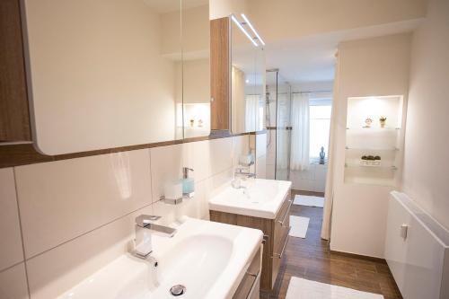 a white bathroom with two sinks and a mirror at Altstadt-Chalet @Conny's in Brilon