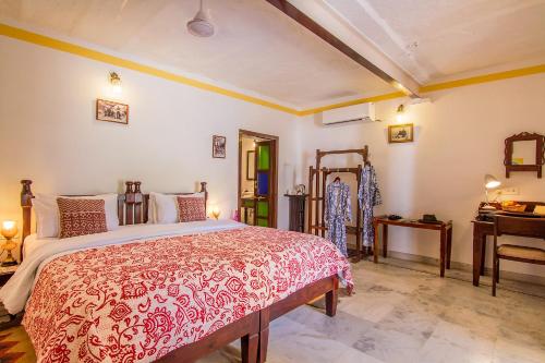 a bedroom with a bed with a red and white bedspread at Rawla Bisalpur in Jawāi Bāndh