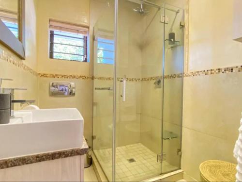 y baño con ducha acristalada y lavamanos. en 3 Sea View Lodge, en Langebaan